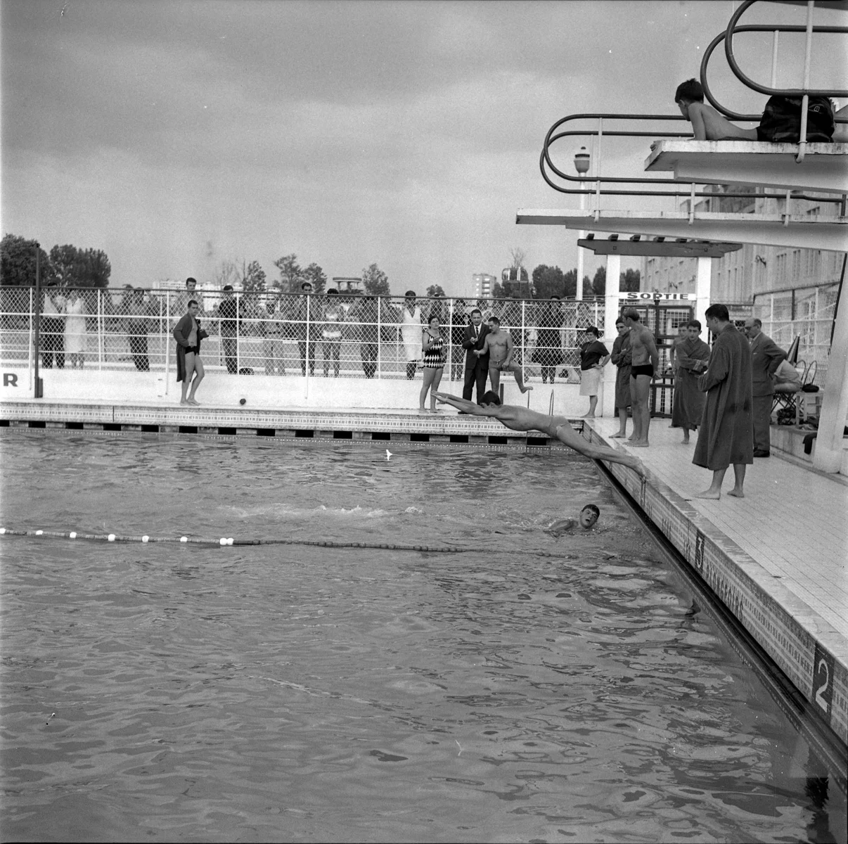 Alain Mosconi plonge à la piscine Castex le 27 juillet 1964. Photographie historique.